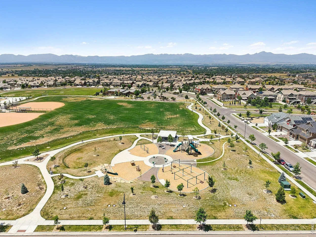 Aerial view of the Erie Highlands park, ball field and trails with the Rockies beyond