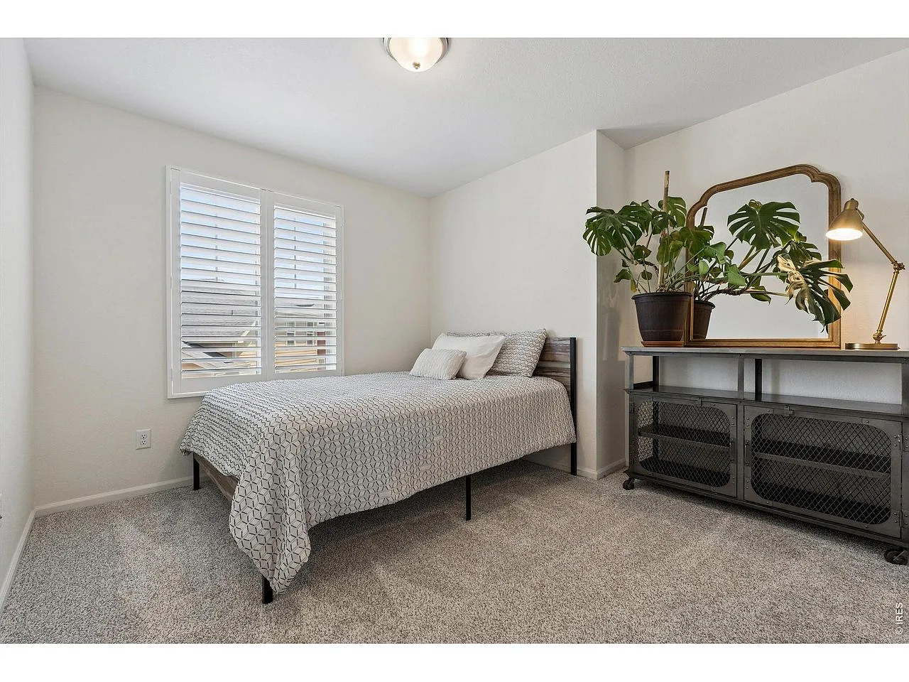 Guest bedroom with plantation shutters and soft carpet