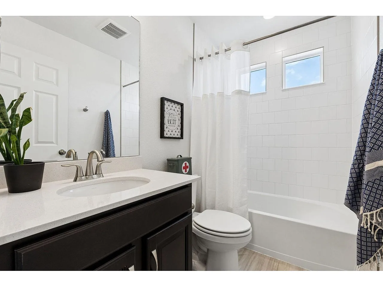 Full hall bathroom with quartz vanity and subway-tile tub shower
