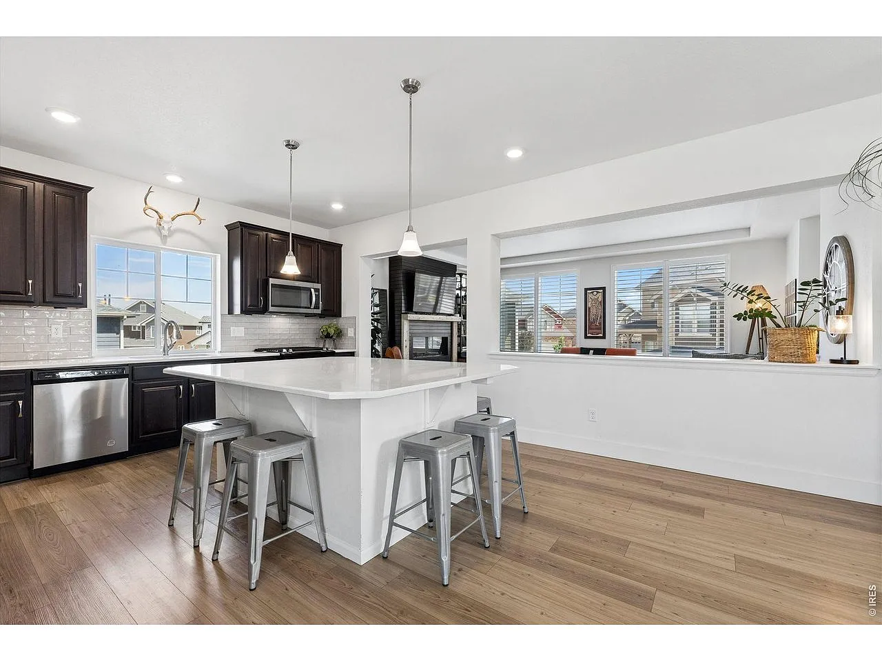 Kitchen island with stool seating open to the sunny dining area