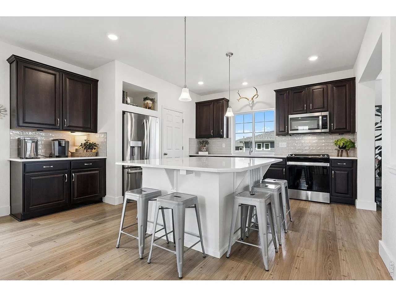 Island kitchen with white quartz counters and espresso cabinetry