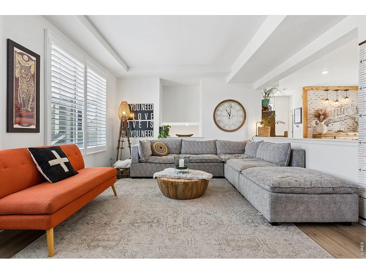 Living room with sectional seating, tray ceiling and plantation shutters
