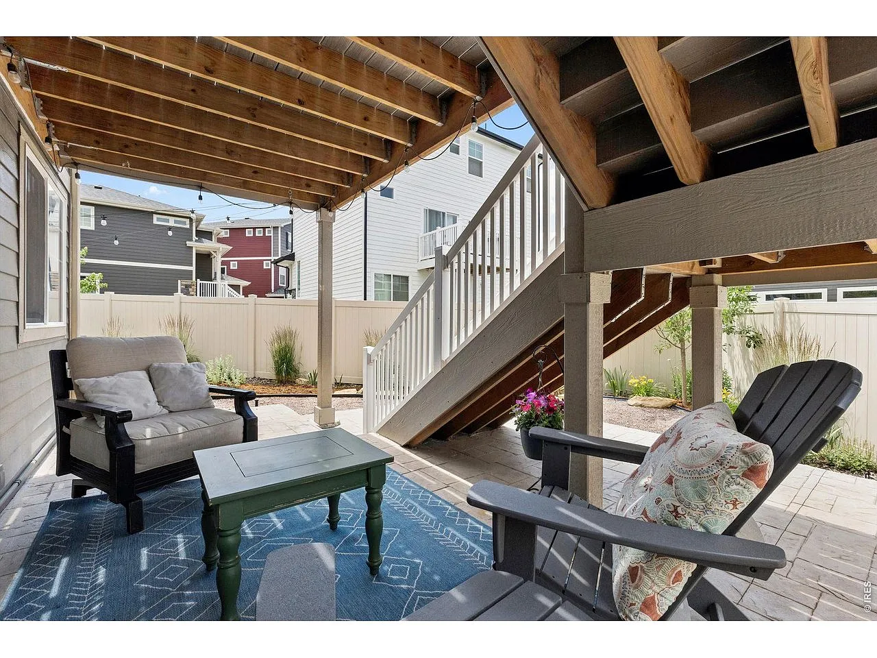 Covered paver patio tucked beneath the deck stairs