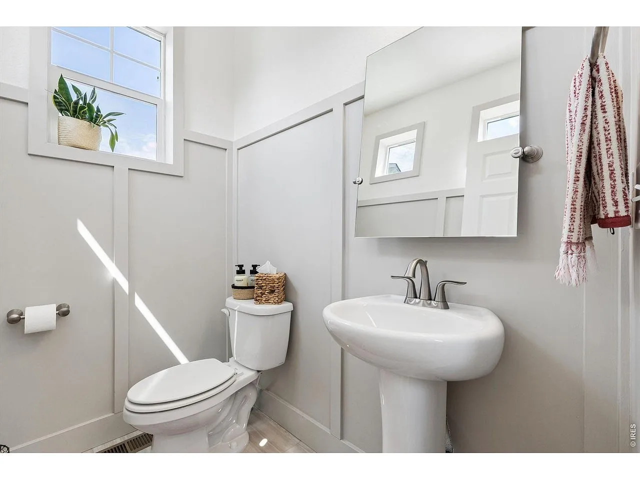 Powder room with pedestal sink and board-and-batten wainscoting