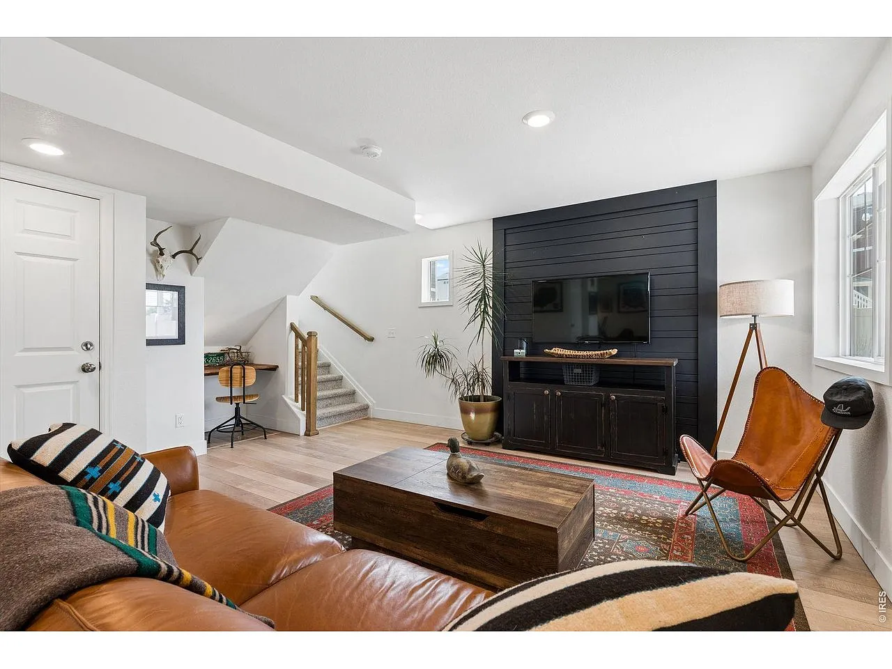 Rec room media wall in black shiplap with wide-plank floors